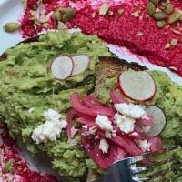 Smashing Avocado · Avocado tossed with feta, lime, cilantro on top of thick cut multigrain toast. Garnished wit...