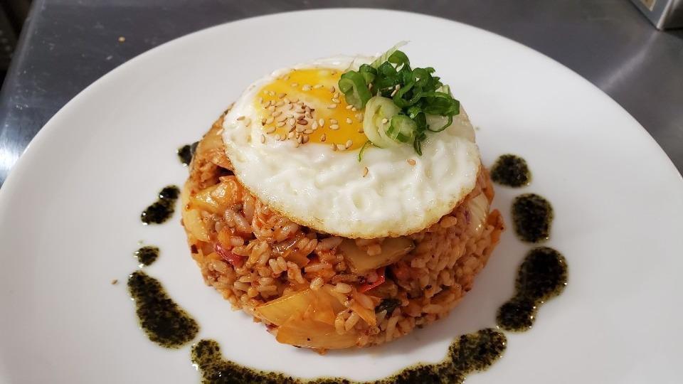 Kimchi Fried Rice · Spicy. Pork or veggie. Rice, onion, scallion, peppers, kimchi, sunny side egg, and sesame seeds.