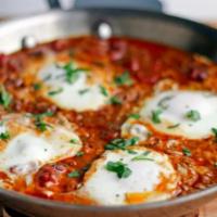 Shakshuka Morning · Two eggs cooked over easy in a spiced tomato sauce. Served with salad and drinks. Drinks onl...