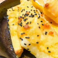 Cheese Saganaki · lightly battered kefalograviera cheese topped with Cretan Greek honey and black sesame seeds