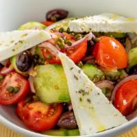 Horiatiki · The classic greek village salad with fresh tomatoes, onions, cucumbers, capers, kalamata oli...