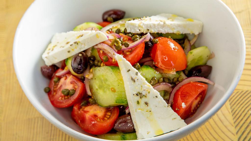 Horiatiki · The classic greek village salad with fresh tomatoes, onions, cucumbers, capers, kalamata olives, feta, and a simple dressing of extra-virgin Greek olive oil and red wine vinegar.