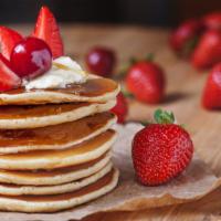 Buttermilk Pancakes With Fresh Strawberries · 3 fluffy golden pancakes topped with fresh strawberries and served with a side of syrup and ...