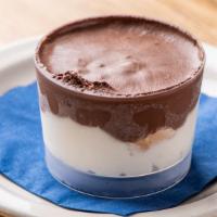 Profiteroles · Three cream puffs surrounded by vanilla and chocolate cream.