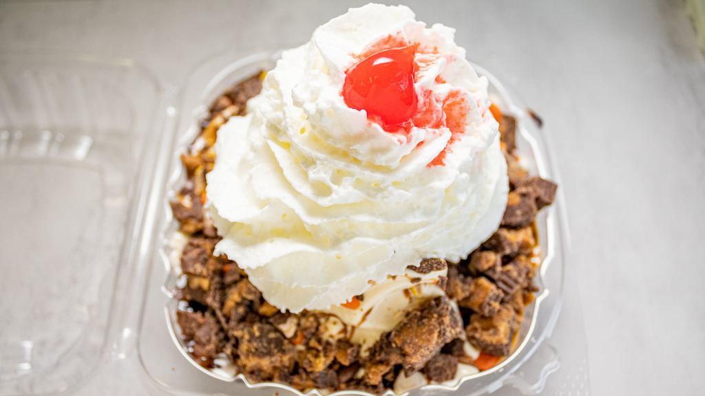 Fat Cow Sundae · Choice of ice cream with hot fudge and peanut butter topping, reeses pieces and reeses peanut butter cups.