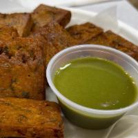 Kothimbir Wadi · Crispy fritters made from cilantro and chickpea flour, steamed and deep-fried. Served with c...