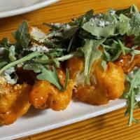 Buffalo Cauliflower · Beer-battered cauliflower tossed in buffalo sauce over house-made blue cheese dressing toppe...