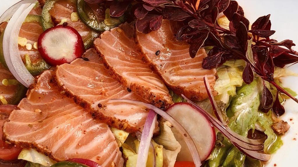 Salmon Salad · Seared salmon with shichimi seasoning, jalapeno, spring mix, lettuce, grape tomato, red onion, radish, baby carrot with wasabi-yuzu dressing.