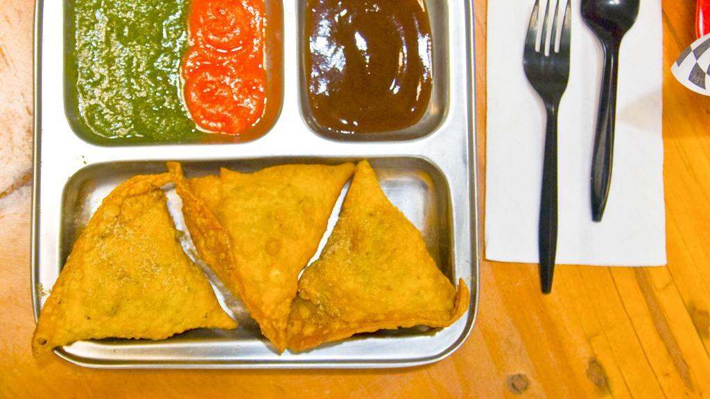 Vegetable Samosa (1 Piece) · Crispy triangle pastry filled with mildly spiced potatoes & peas.