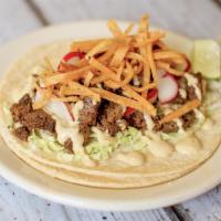 Carne Asada Taco · Grilled marinated steak, crispy tortilla strips, and chili crema. Served on soft corn tortil...