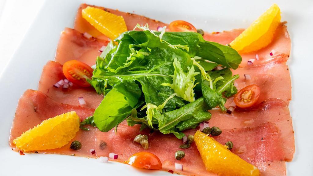 Carpaccio Di Tonno · Sushi-grade, thinly sliced cured tuna with capers, onions, extra virgin olive oil, and lemon served with arugula salad.
