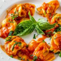 Tortelloni Al Pomodoro · Homemade large tortellini filled with veal and chicken in a tomato sauce.