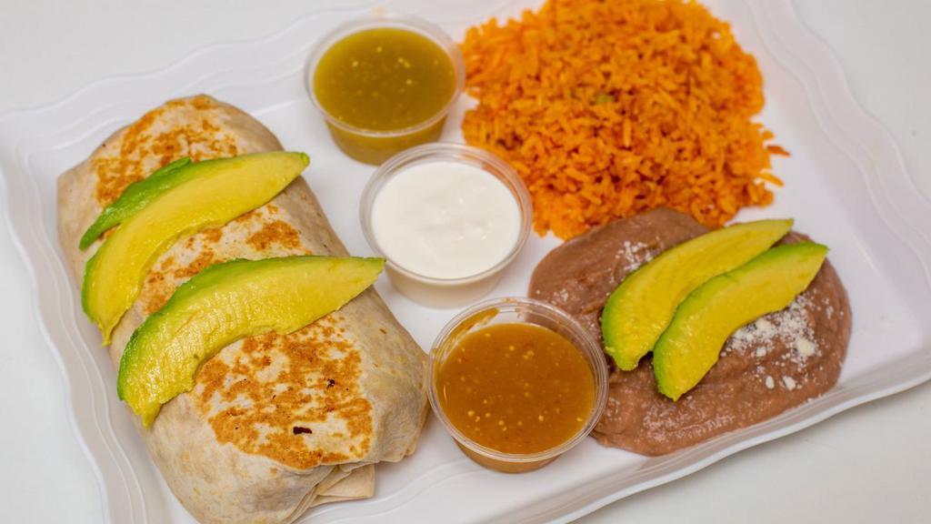 Bistec Burrito · Grilled Steak, Flour Tortilla Topped with Refried Beans Lettuce, Oaxaca Cheese, Avocado, and Mexican Orange Rice Inside The Burrito Plates Are Served With Mexican Orange Rice And Refried Beans Topped With Powder Cheese And a side Of Mexican Sour Cream