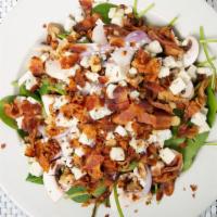 Spinach Salad · Fresh spinach leaves with bacon, walnuts, red onion, gorgonzola cheese and mushrooms in a de...