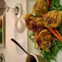 Thai Dumpling · Wonton skin stuffed with chicken, shrimp, crab meat and bamboo shoots, served with Thai sauce.