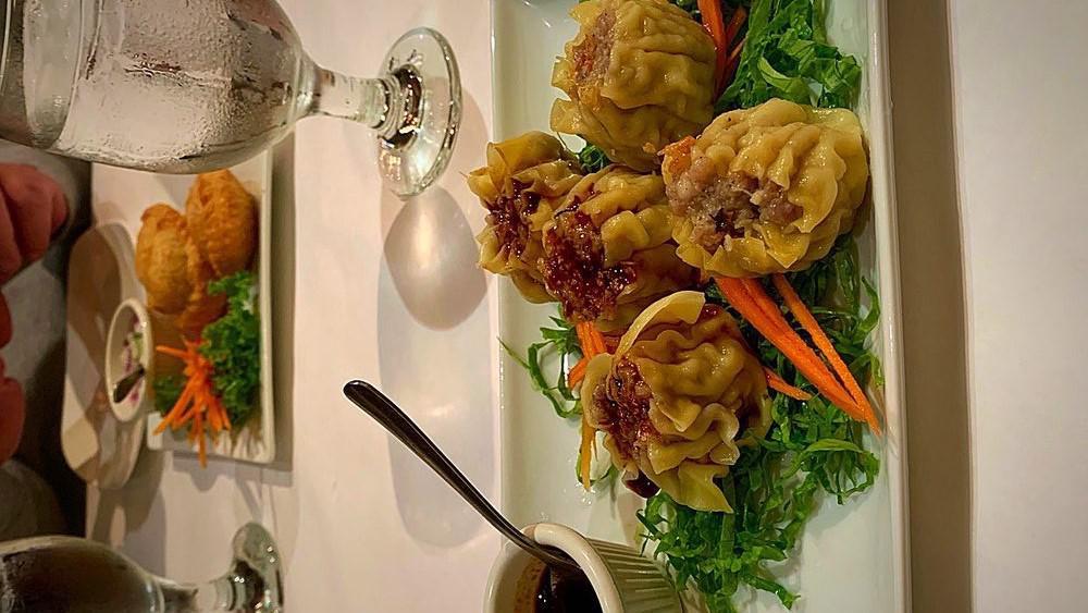 Thai Dumpling · Wonton skin stuffed with chicken, shrimp, crab meat and bamboo shoots, served with Thai sauce.