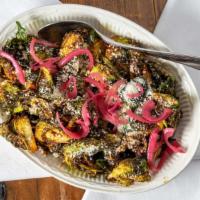 Adobo Brussels · Crispy brussel sprouts tossed with salsa and topped with cotija cheese and pickled onions.  ...