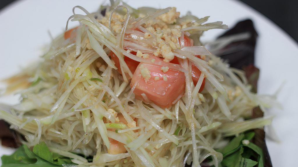 Green Papaya Salad · Green papaya with tomatoes, minced string beans, and topped with ground peanuts and spicy lime juice dressing. Spicy.