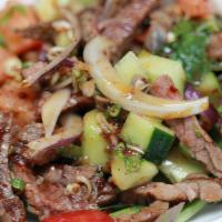 Grilled Steak Salad · Grilled steak with mixed greens, tomatoes, bell pepper, cucumber, onion, thai herbs, and chi...