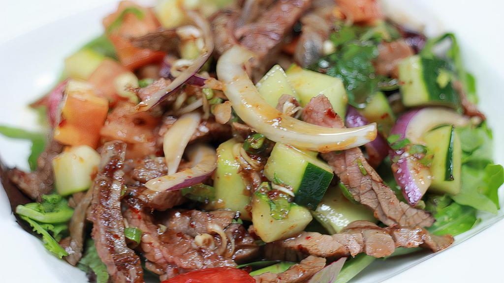 Grilled Steak Salad · Grilled steak with mixed greens, tomatoes, bell pepper, cucumber, onion, thai herbs, and chili lime juice. Spicy lowest level mild.