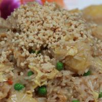 Pineapple Fried Rice · Coconut flavored fried rice with pineapple, onions, carrots, peas, and egg topped with groun...