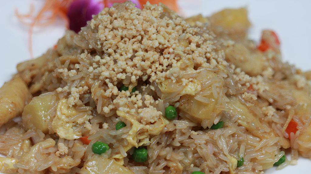Pineapple Fried Rice · Coconut flavored fried rice with pineapple, onions, carrots, peas, and egg topped with ground peanuts.