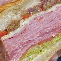 Muffaletta Sandwich · Salami, ham, prosciutto, provolone, olive salad, lettuce, tomato, oil, and vinegar on a roll.