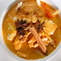 Massaman Curry · Spicy. Pearl onion, peanut, lotus seeds and grilled potatoes with coconut milk. Served with ...
