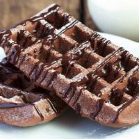 Nutella Waffle · Golden Belgian waffle topped with a Nutella drizzle and served with a side of maple syrup.