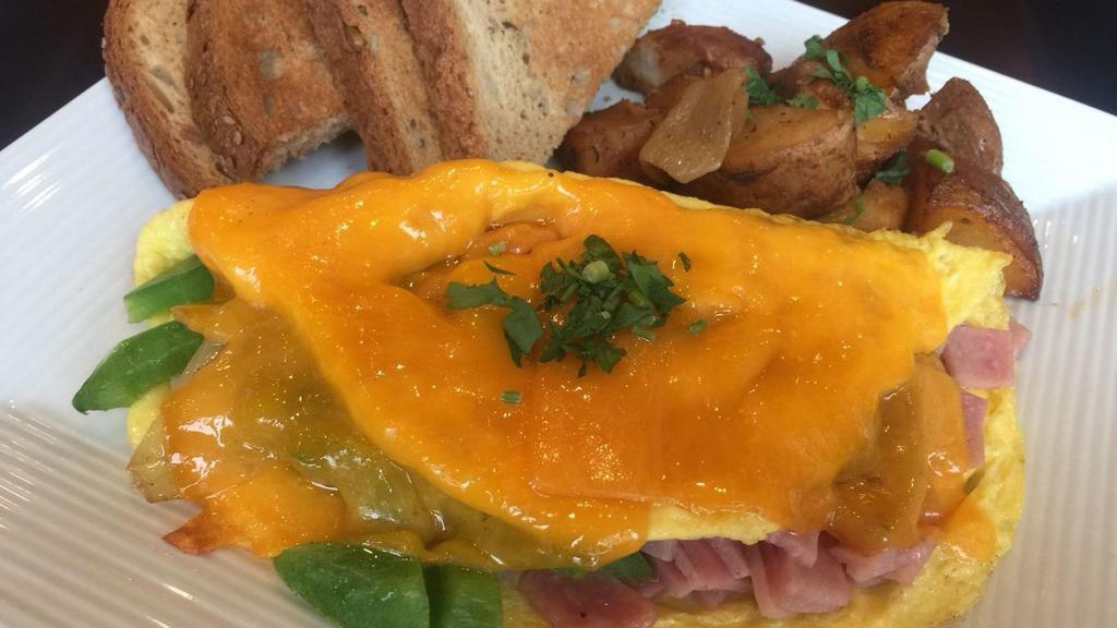 Western Cheese Omelette · 3 eggs stuffed with ham, onions, peppers and cheddar cheese, served with home fries and toast.