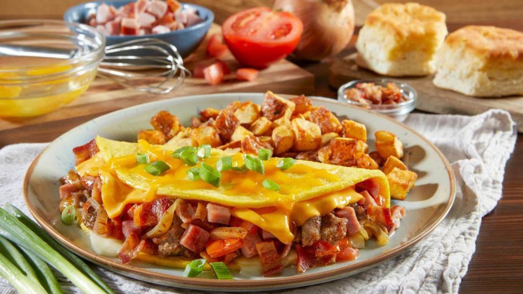 Three Meat & Cheese Omelet · Loaded with hickory-smoked ham, hardwood-smoked bacon, farm-famous sausage, real provolone cheese, American cheese, caramelized onions and diced tomatoes. Finished with real cheddar cheese and green onions. Served with your choice of hash browns or home fries.