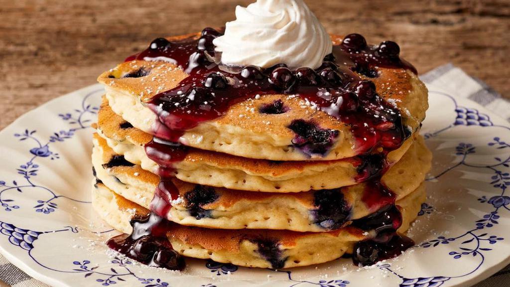 Double Blueberry Hotcakes · Four blueberry hotcakes topped with blueberry topping, whipped topping and powdered sugar. Served with your choice of premium breakfast meat or fresh fruit