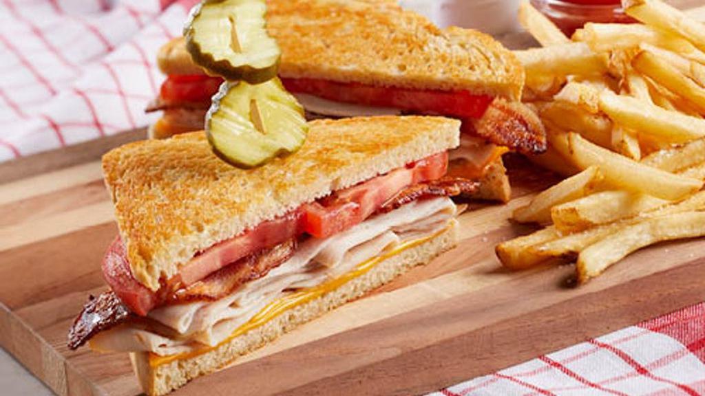 Slow-Roasted Turkey Bacon Melt · Slow-roasted shaved turkey topped with American cheese, tomato and bacon on grilled sourdough bread and garnished with deli pickles. Served with choice of one or two sides