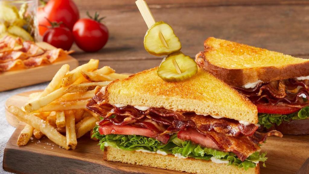 All American Blt · Four strips of center-cut hardwood-smoked bacon, lettuce, tomato and mayo on griddled brioche bread served with deli pickles.