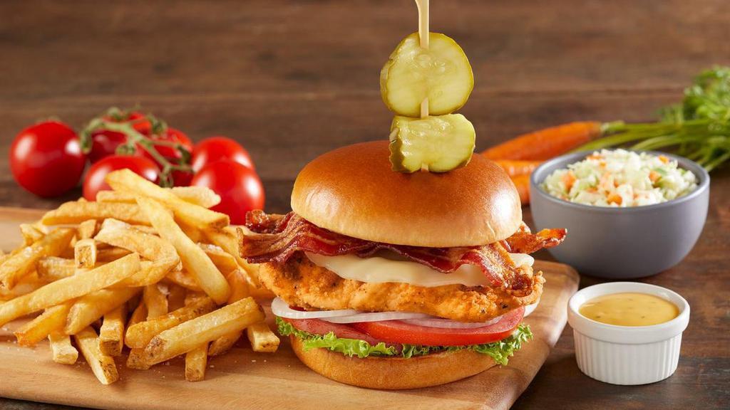 Farmhouse Hand-Breaded Fried Chicken Sandwich · Hand-breaded fried chicken breast topped with real provolone cheese, center-cut bacon, lettuce, tomatoes, onion and pickles on a toasted brioche bun.  Served with honey mustard.
