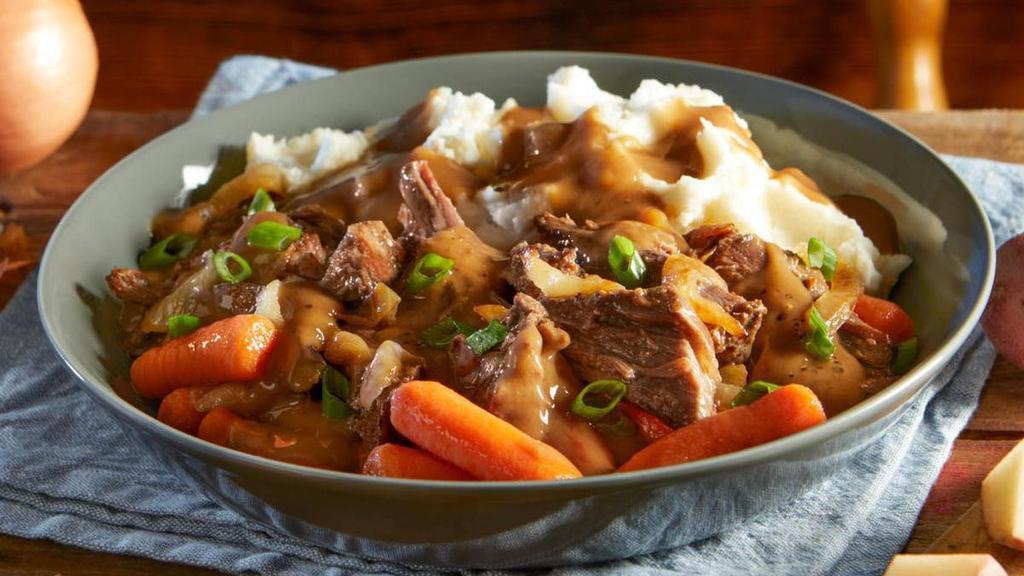 Fork-Tender Pot Roast · Slow-roasted for nine hours and served with carrots, caramelized onions, mashed potatoes and homestyle beef gravy, finished with crisp green onions and served with dinner rolls