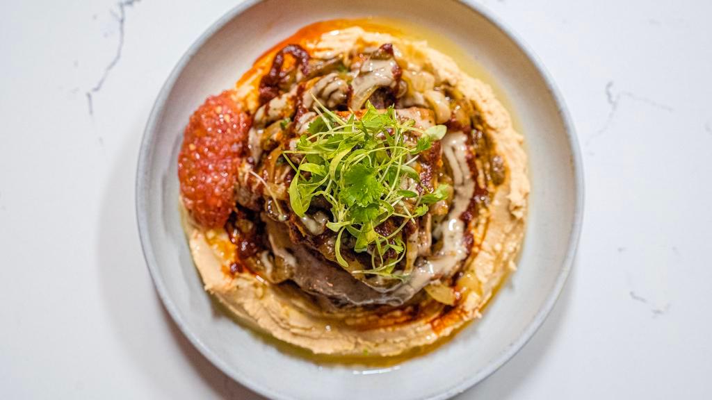 Israeli Souvlaki Sandwich · Grilled Marinated Boneless Chicken Leg & Thigh, Shaved Veal & Lamb, Grilled Onion & Cabbage, Green Tahini, Amba Coulis, Romanian Salsa, Chipotle Pepper, Pine Nuts, Fresh Herbs...  All Inside a Pita!