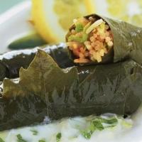 Yaprak Dolma / Stuffed Grape Leaves · Rice, currants, onions, isot pepper, pomegranate molasses, herbs and olive oil rolled with g...
