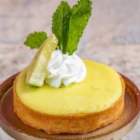 Key Lime Tart · It has a thick crust and a tangy lime filling garnished with a fresh lime on top.