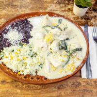 Pollo En Rajas · Chicken breast layered with slices of poblano pepper in a cream sauce with corn. Served with...
