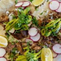 Carnitas Tacos · Three tacos served on corn tortilla with cilantro onions and avocado.