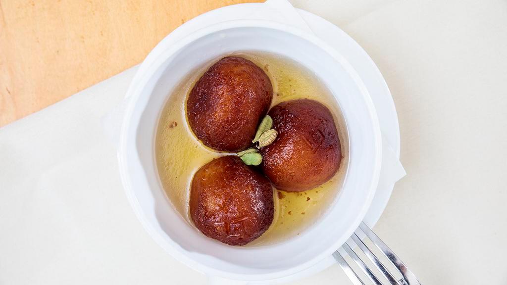 Gulab Jaman · Traditional deep-fried milk pastry served in rosewater honey syrup with a sprinkle of crushed pistachios.