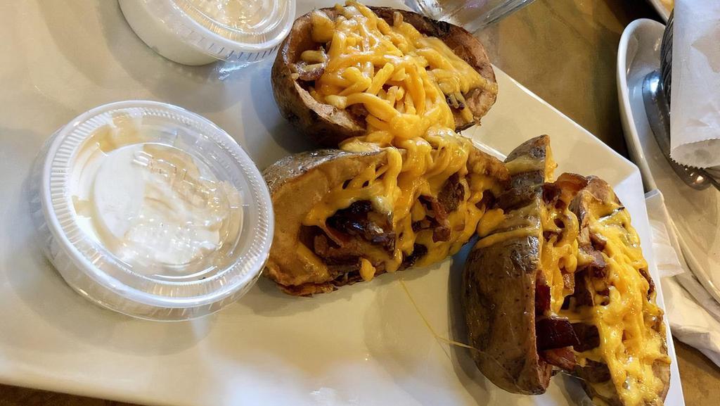 Potato Skins · Stuffed with cheddar cheese and topped with bacon and served with sour cream.