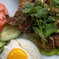 Grilled Lemongrass Pork Chops · 2 center cut pieces, cucumbers, tomatoes, sunny-side up egg, scallion, served with rice