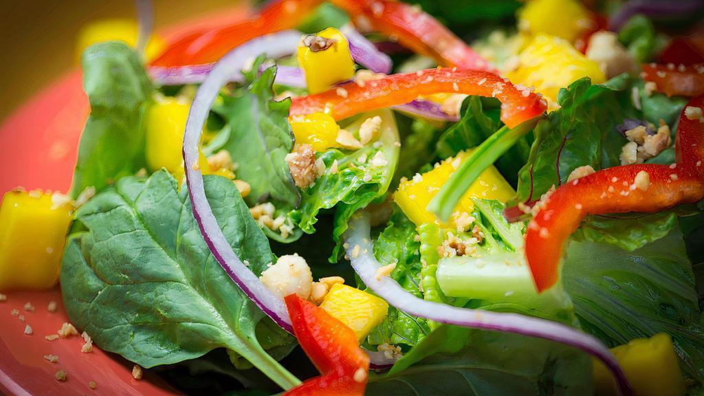 Mixed Green Salad · Mixed greens with red bell peppers, red onions, mac nuts, mango and your choice of dressing