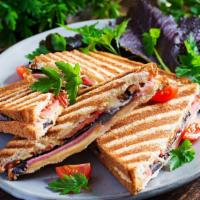 Turkey Club Panini · Grilled Panini Sandwich made with Turkey, bacon, lettuce, tomatoes, and house dressing.