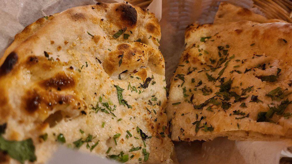 Garlic Naan · Crispy and fluffy bread made with freshly minced garlic and coriander leaves.