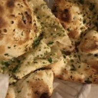 Garlic Naan · Best of the beast breads. Unleavened white flour flat bread, specked with crushed garlic & b...