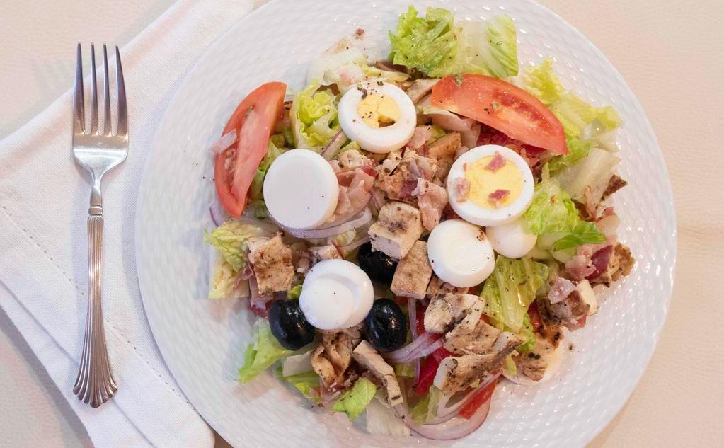 Cobb Salad · Romaine lettuce, tomatoes, red onions, roasted red peppers, black olives, sliced egg, grilled chicken, and bacon.
