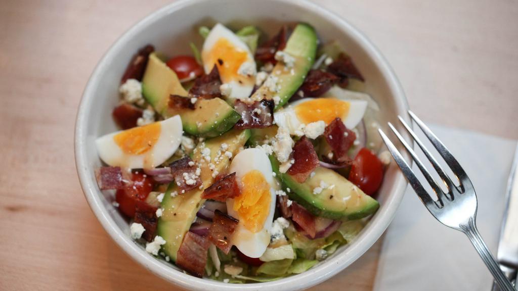 Whitmans Cobb Salad · Iceburg lettuce, blue cheese crumbles, avocado, tomato, crispy applewood smoked bacon, hard boiled egg wedges, red onions, house-made balsamic vinaigrette.